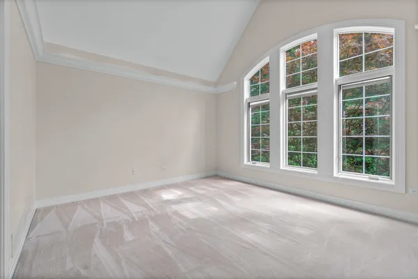 a view of an empty room with wooden floor and a fireplace