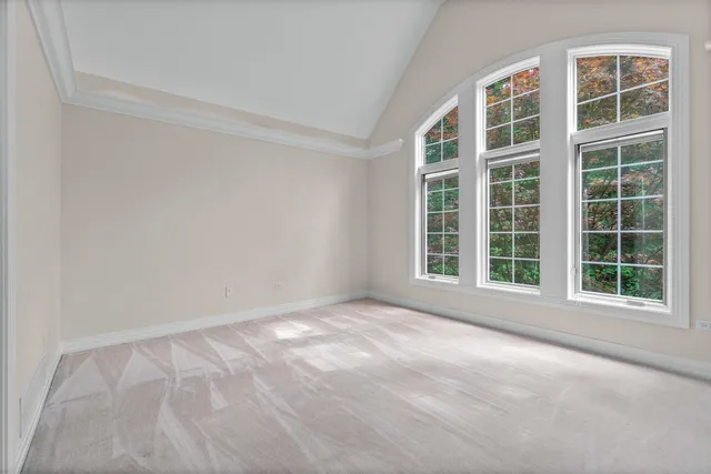 a view of an empty room with wooden floor and a fireplace