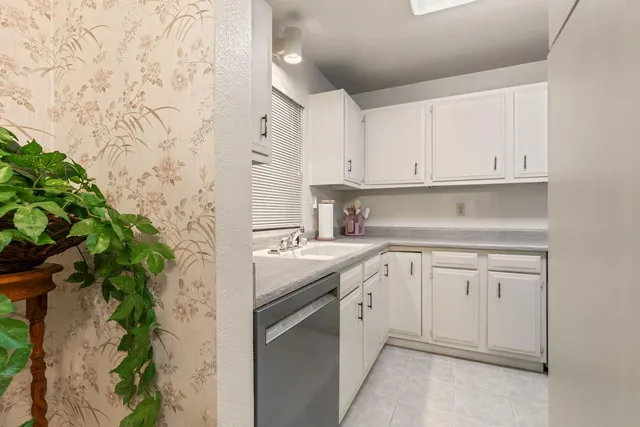 a kitchen with stainless steel appliances white cabinets and a sink