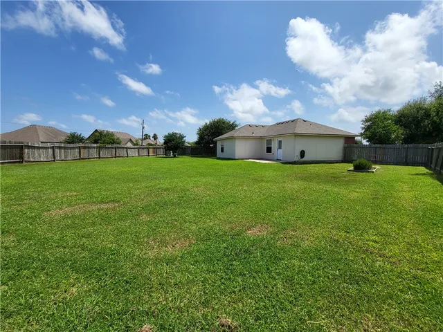 a view of a big yard with a house in the background