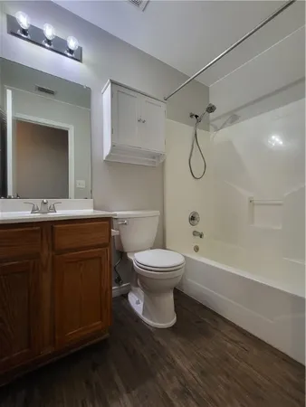 a bathroom with a granite countertop toilet sink and a mirror