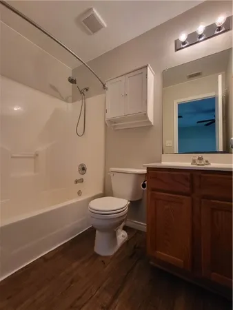 a bathroom with a toilet a sink a mirror and bathtub