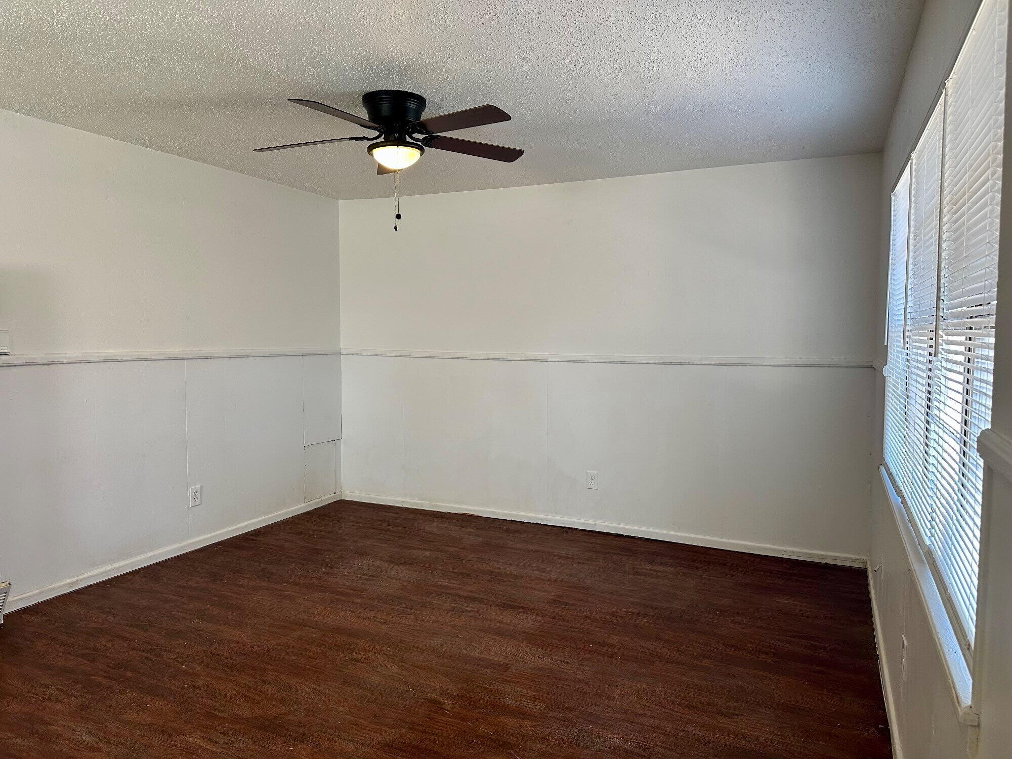1119 46th Street, Unit B Lubbock, TX 79412 - Photo 3 of 9 an empty room with wooden floor and window