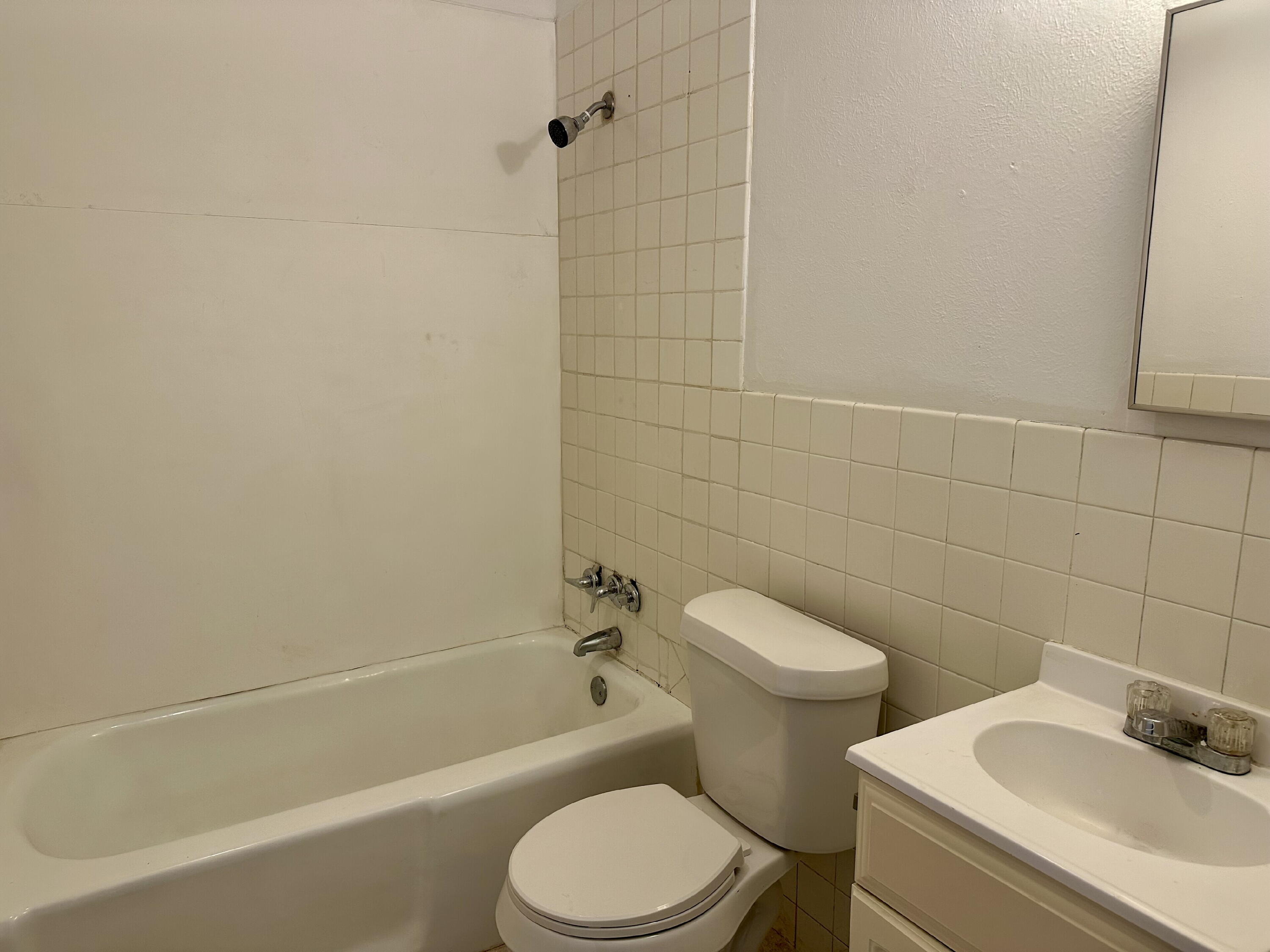 1119 46th Street, Unit B Lubbock, TX 79412 - Photo 6 of 9 a white toilet and tub sitting next to a bathroom sink