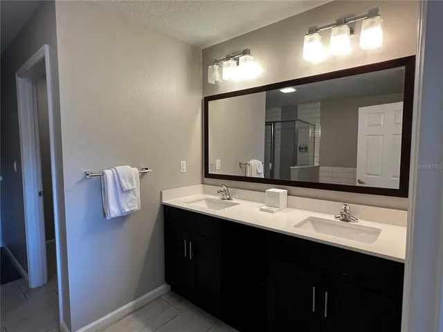 a bathroom with a double vanity sink and a mirror
