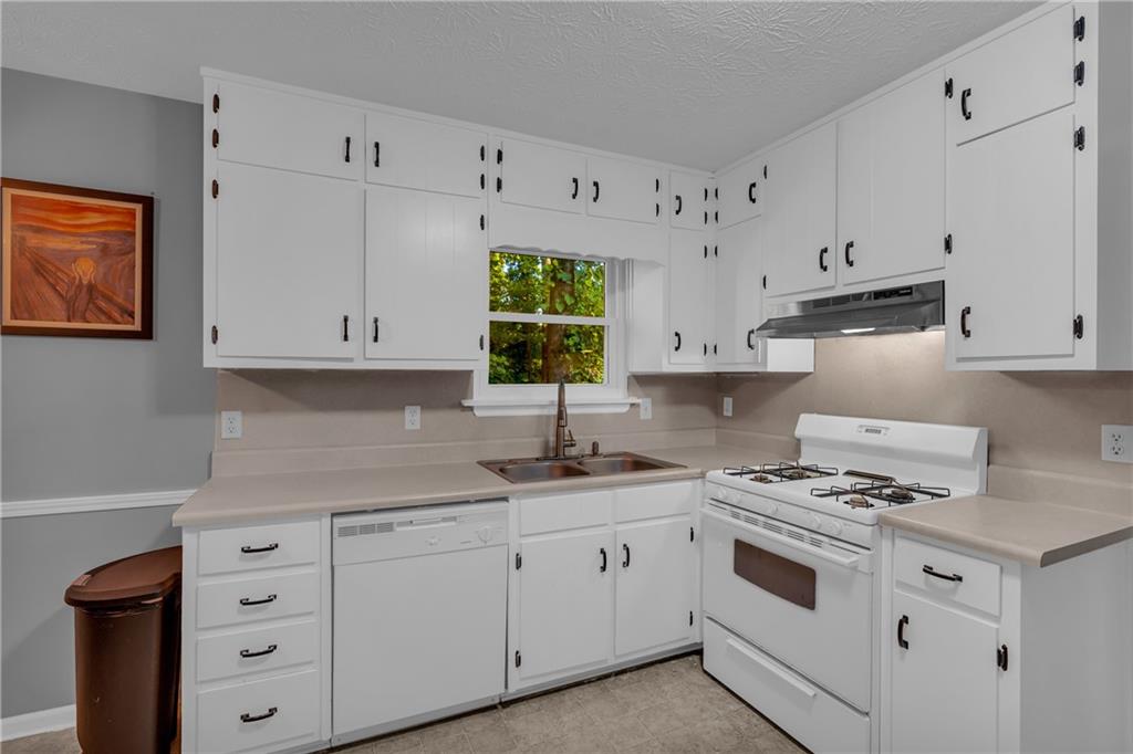 4907 Habersham Ridge Southwest Lilburn, GA 30047 - Photo 25 of 76 a kitchen with cabinets appliances a sink and a window