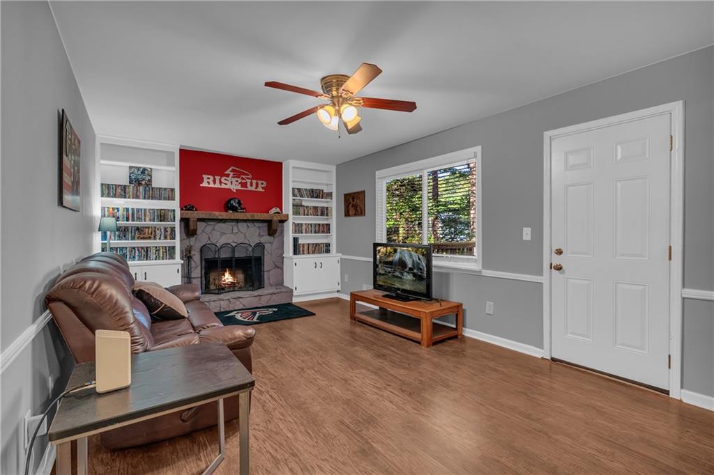 4907 Habersham Ridge Southwest Lilburn, GA 30047 - Photo 27 of 76 a living room with furniture a fireplace and a flat screen tv