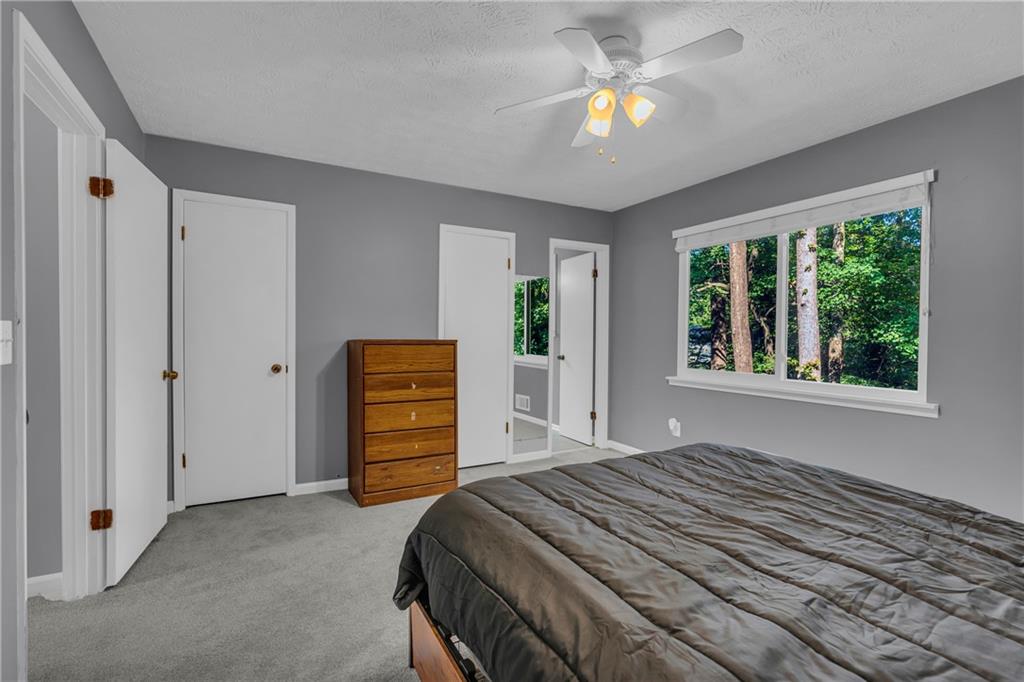 4907 Habersham Ridge Southwest Lilburn, GA 30047 - Photo 34 of 76 a bedroom with a bed and a chandelier