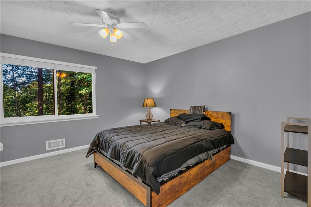 4907 Habersham Ridge Southwest Lilburn, GA 30047 - Photo 38 of 76 a bedroom with a bed and a chandelier