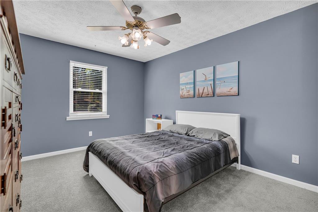 4907 Habersham Ridge Southwest Lilburn, GA 30047 - Photo 42 of 76 a bedroom with a bed chandelier and a window