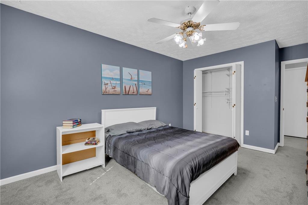 4907 Habersham Ridge Southwest Lilburn, GA 30047 - Photo 44 of 76 a bedroom with a bed and a chandelier