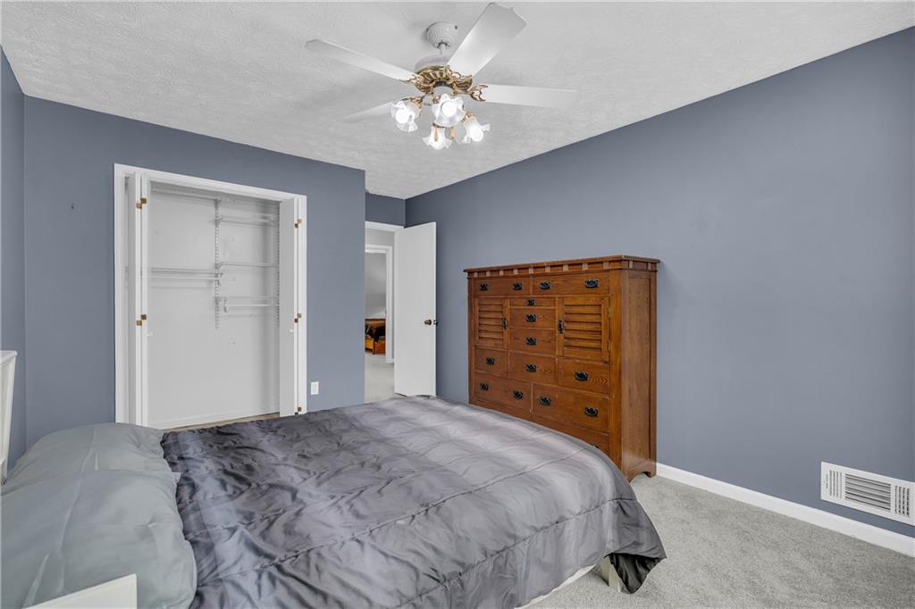 4907 Habersham Ridge Southwest Lilburn, GA 30047 - Photo 45 of 76 a bedroom with a large bed and a chandelier