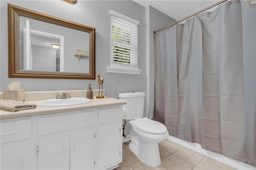 4907 Habersham Ridge Southwest Lilburn, GA 30047 - Photo 47 of 76 a bathroom with a sink a toilet and shower