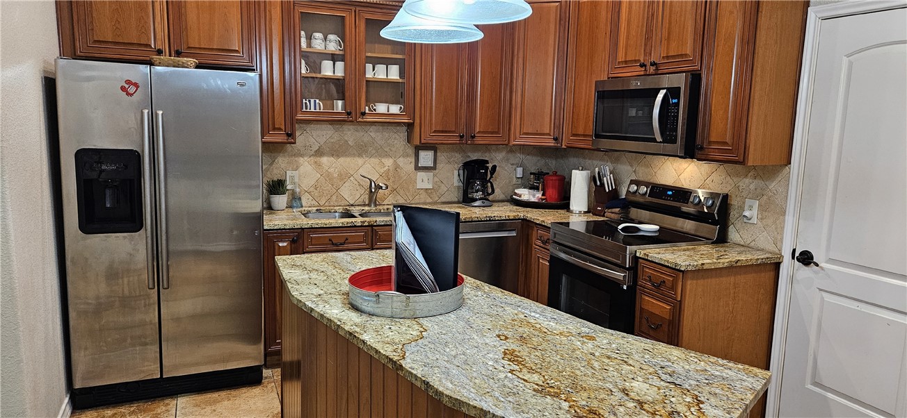 14334 Cruiser Street, Unit 202A Corpus Christi, TX 78418 - Photo 11 of 38 a kitchen with stainless steel appliances granite countertop a refrigerator a stove and a sink