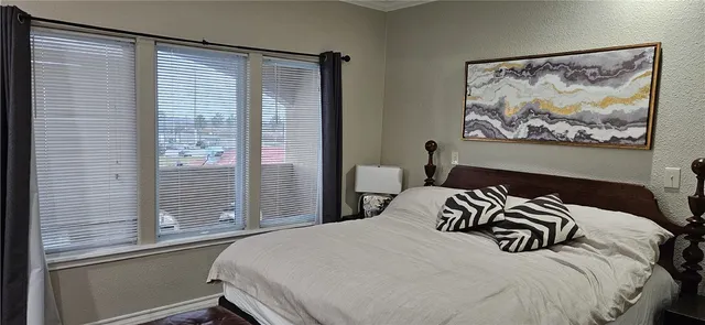 a bedroom with a bed and a painting on the wall