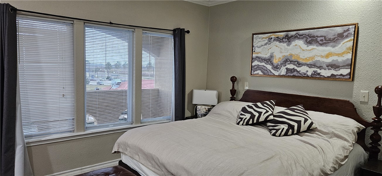 14334 Cruiser Street, Unit 202A Corpus Christi, TX 78418 - Photo 14 of 38 a bedroom with a bed and a painting on the wall