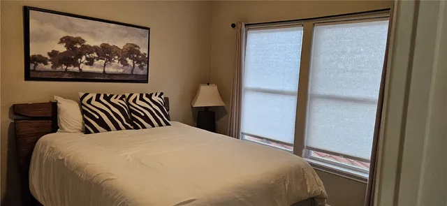 a bed room with a bed and painting on the wall