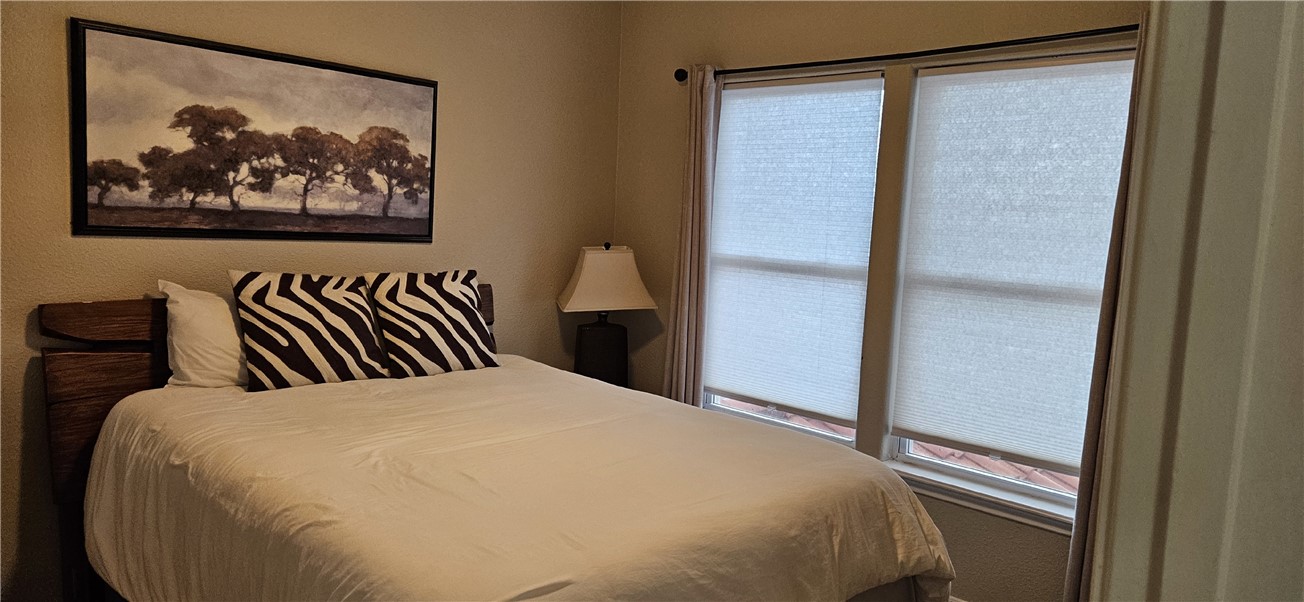 14334 Cruiser Street, Unit 202A Corpus Christi, TX 78418 - Photo 26 of 38 a bed room with a bed and painting on the wall