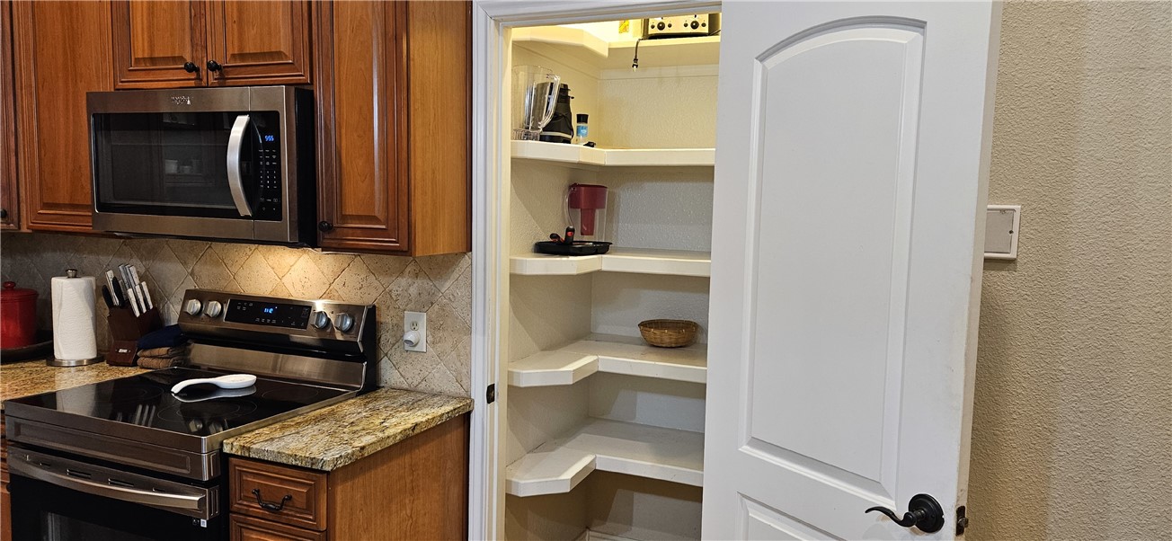 14334 Cruiser Street, Unit 202A Corpus Christi, TX 78418 - Photo 32 of 38 a kitchen with a stove and a microwave
