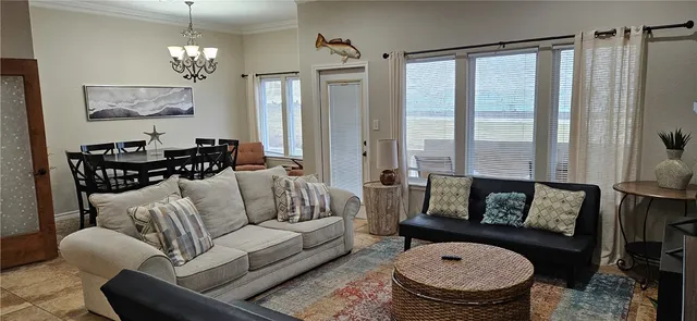 a living room with furniture a fireplace and a chandelier