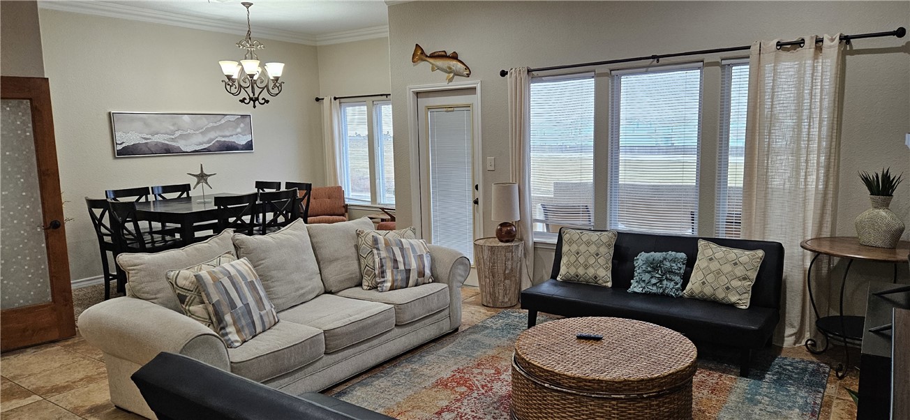 14334 Cruiser Street, Unit 202A Corpus Christi, TX 78418 - Photo 5 of 38 a living room with furniture a fireplace and a chandelier