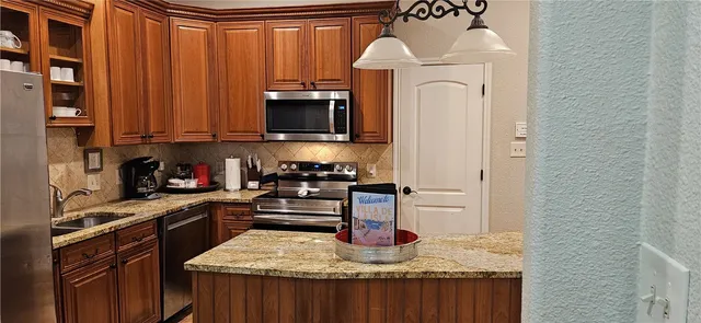 a kitchen with stainless steel appliances granite countertop a stove top oven a sink and dishwasher