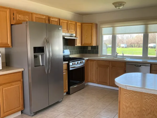a kitchen with stainless steel appliances granite countertop a refrigerator and a sink