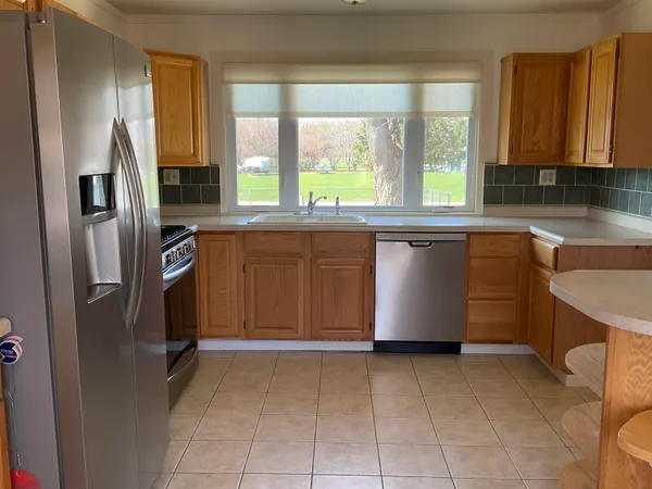 a kitchen with stainless steel appliances granite countertop a stove a refrigerator and a cabinets