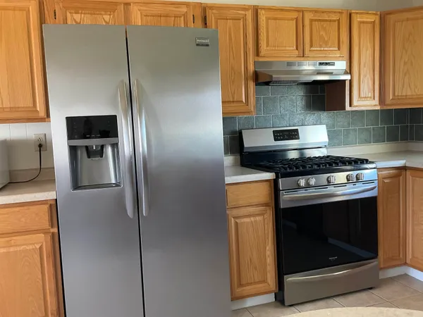 a kitchen with a refrigerator and a chandelier