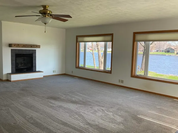 a view of an empty room with a fireplace and a window