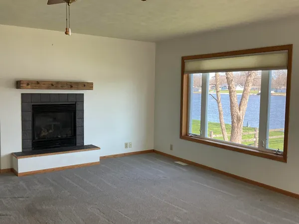 a living room with a fireplace and a large window