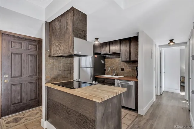 a kitchen with kitchen island granite countertop wooden cabinets and refrigerator