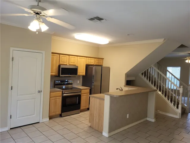 a kitchen with stainless steel appliances a stove microwave and refrigerator