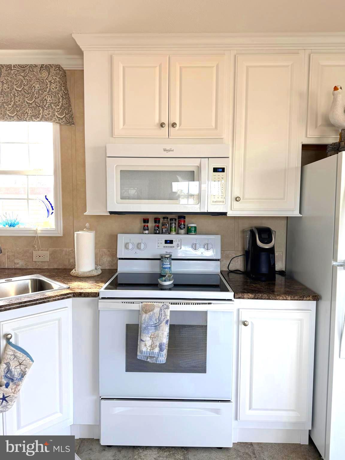 38025 Rabbit Road, Unit 101 Ocean View, DE 19970 - Photo 14 of 112 a kitchen with stainless steel appliances granite countertop a sink stove and white cabinets