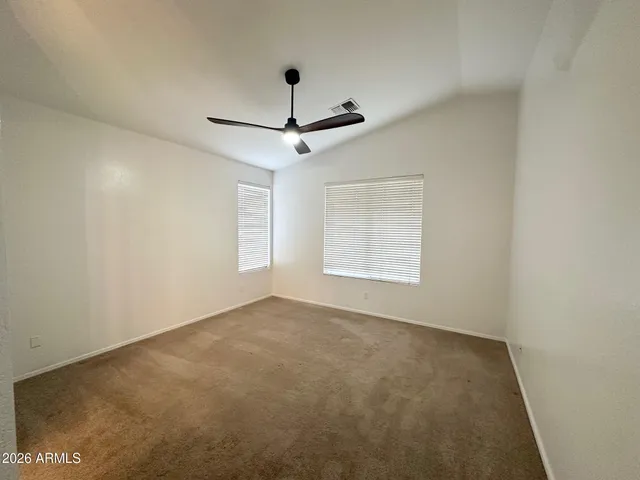 an empty room with a ceiling fan and window