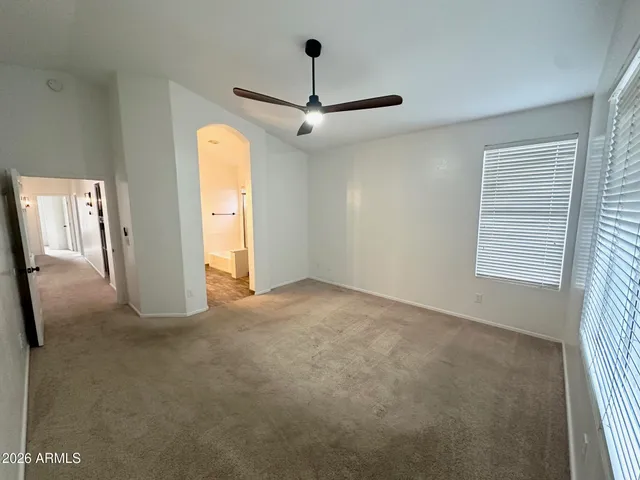en empty room with windows and ceiling fan