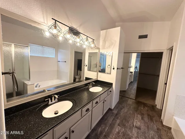a bathroom with a granite countertop double vanity sink and a mirror
