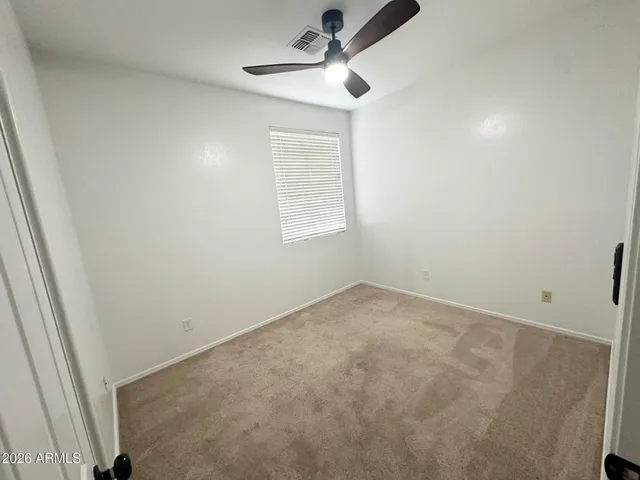 an empty room with a window and a fan