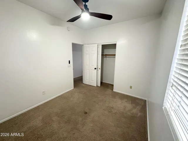 an empty room with closet and windows