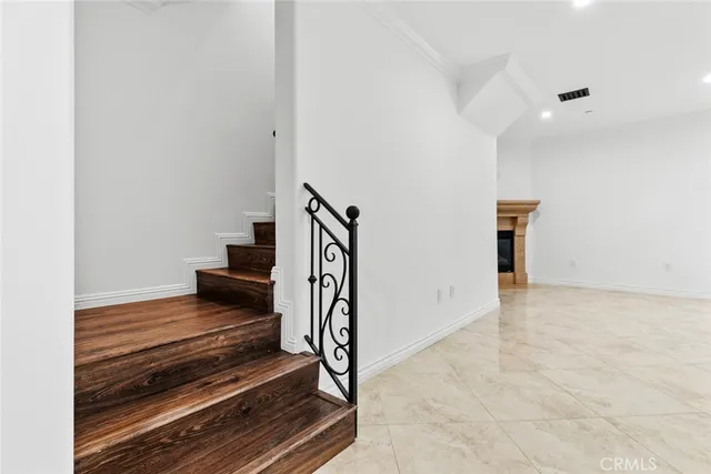 an empty room with windows and fireplace