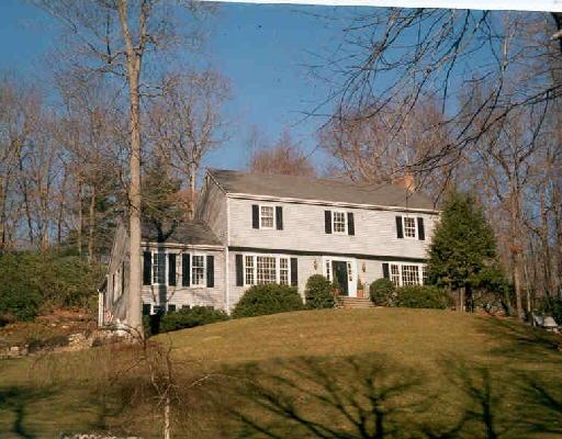 a front view of a house with a yard and lake view