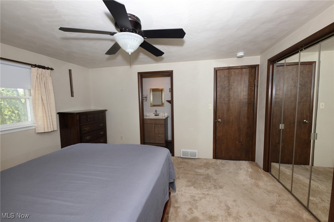 115 Carol Road Wellsburg, WV 26070 - Photo 21 of 36 Bedroom with light colored carpet, a closet, ceiling fan, and ensuite bathroom