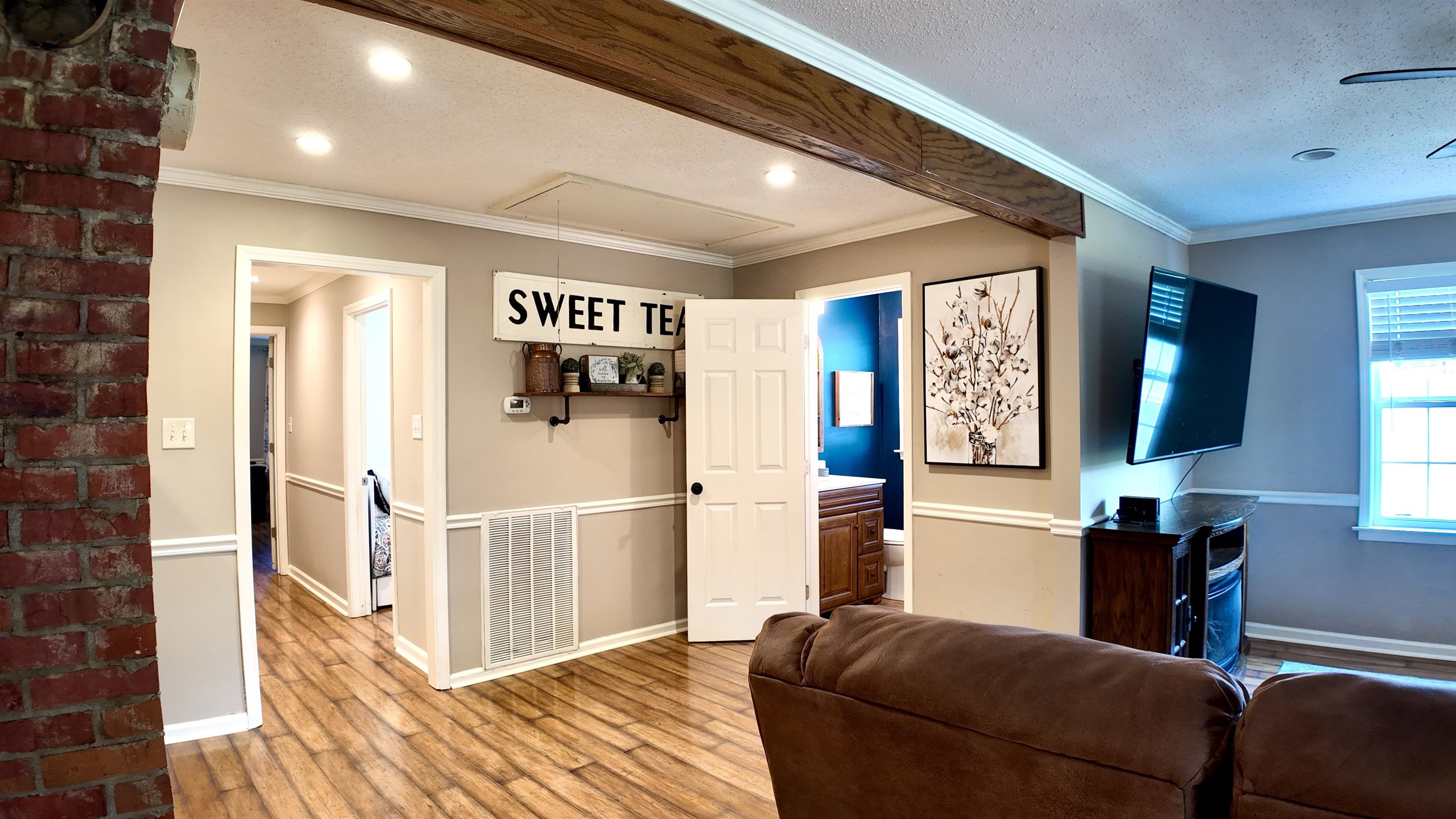 3312 Old Memphis Road Covington, TN 38019 - Photo 17 of 32 Living room with a textured ceiling, ornamental molding, wood-type flooring, and brick wall