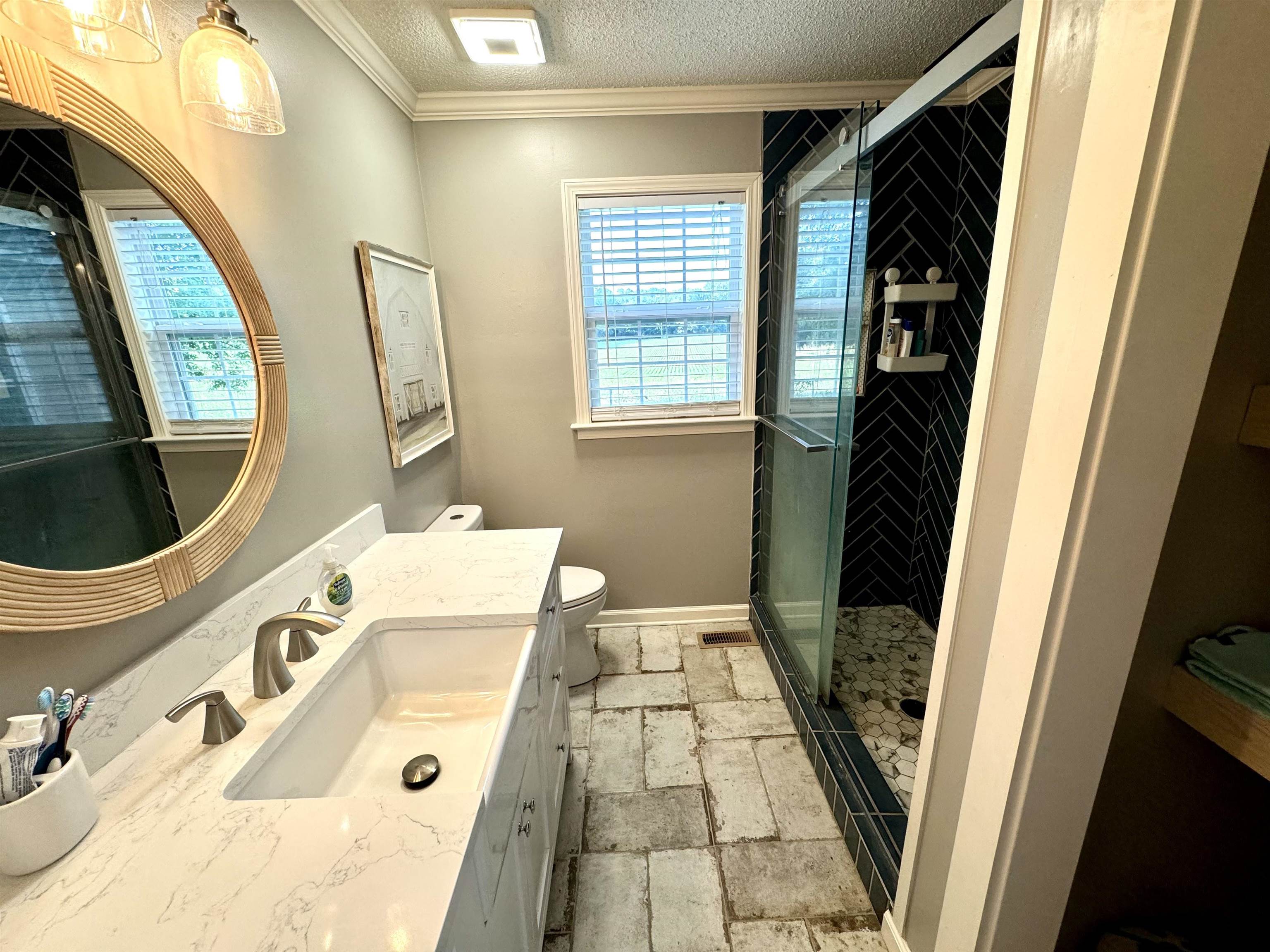 3312 Old Memphis Road Covington, TN 38019 - Photo 22 of 32 Bathroom with crown molding, a textured ceiling, toilet, vanity, and tile patterned floors