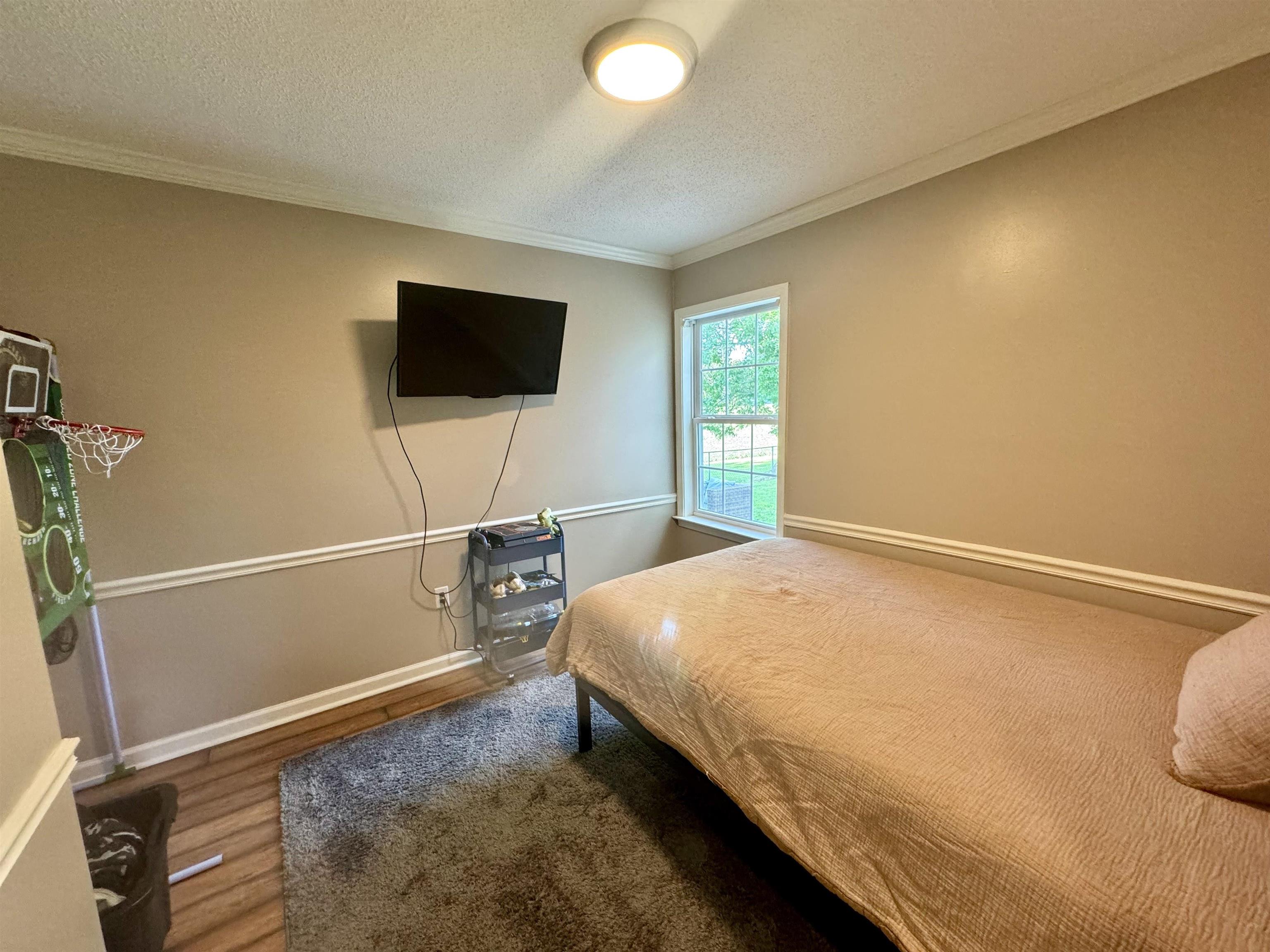 3312 Old Memphis Road Covington, TN 38019 - Photo 26 of 32 Bedroom featuring a textured ceiling, crown molding, and hardwood / wood-style floors