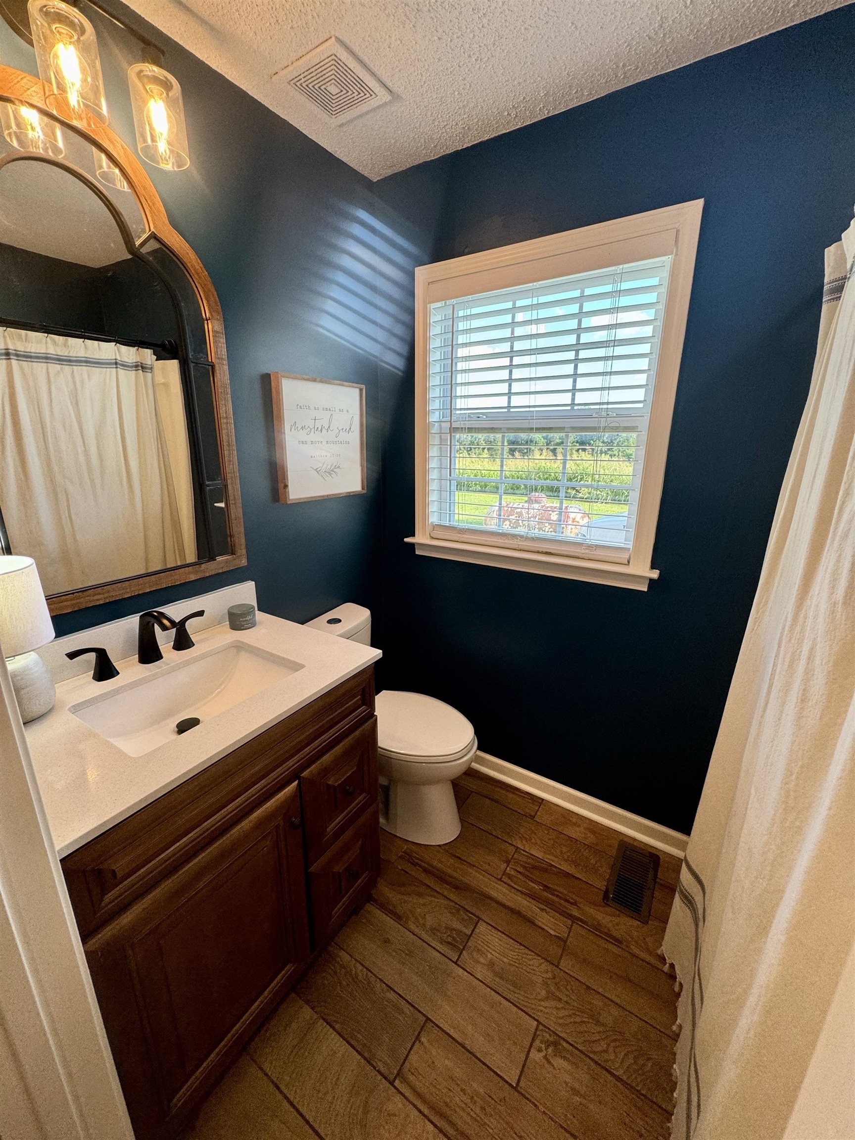 3312 Old Memphis Road Covington, TN 38019 - Photo 27 of 32 Bathroom with vanity, wood-type flooring, a textured ceiling, and toilet