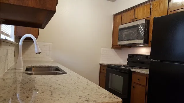 a kitchen with a stove a microwave and sink