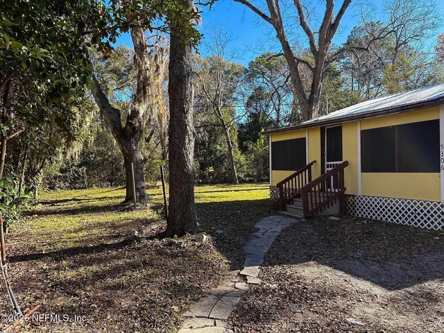 a view of a house with backyard and sitting area
