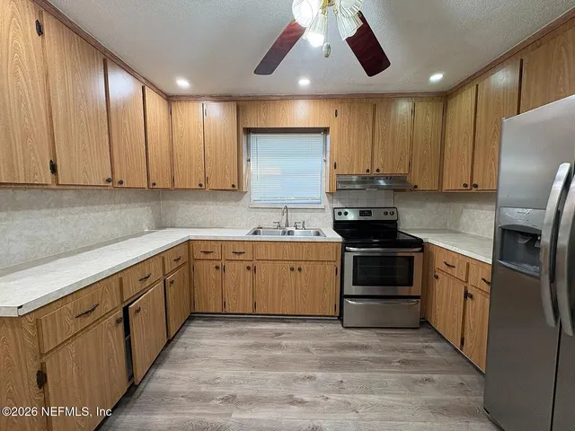 a kitchen with a sink stove and refrigerator