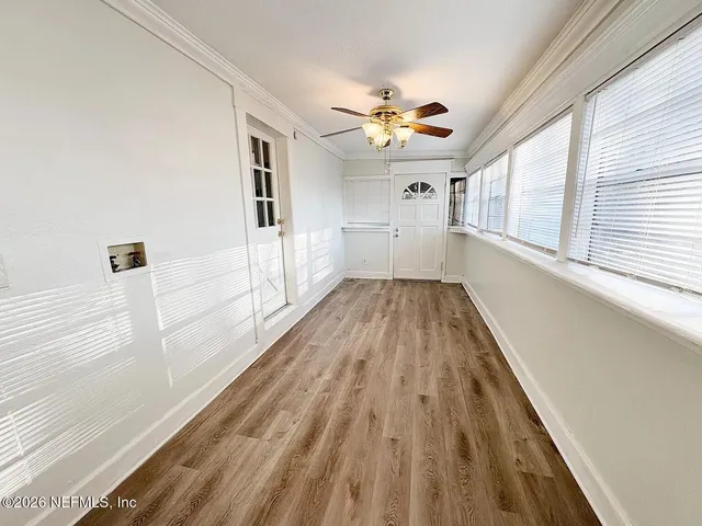 a view of a hallway with wooden floor and chandelier